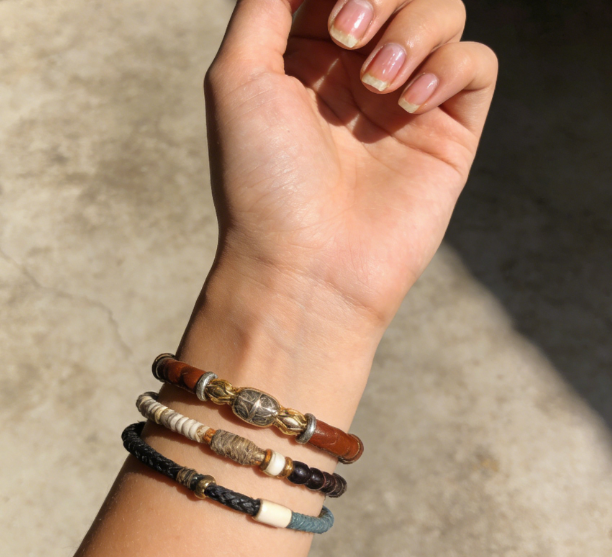 Wooden mala bracelet with 18 beads resting on open palm in natural light