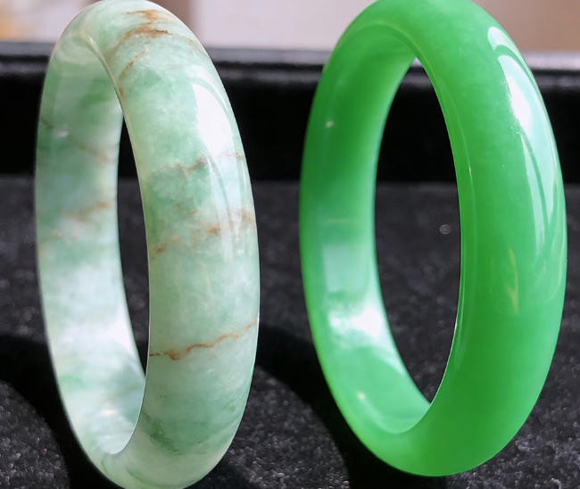 Side-by-side comparison of genuine nephrite jade bracelet with natural color variations versus fake jade with uniform artificial coloring